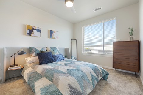 A bedroom with a bed, nightstand, and a lamp.