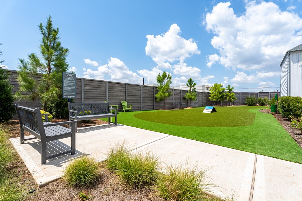 A park with a bench and a green lawn.