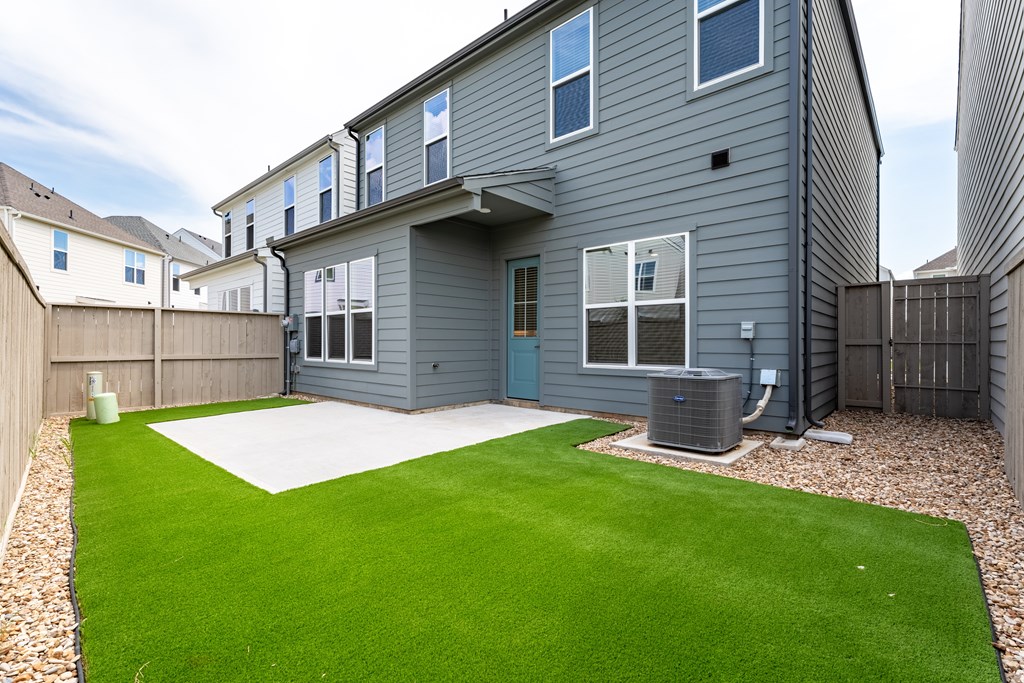 A grey house with a green lawn in front.