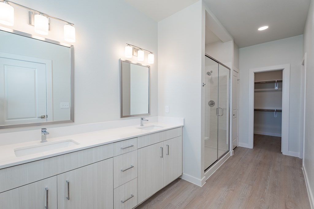 A bathroom with a white vanity and a large mirror.