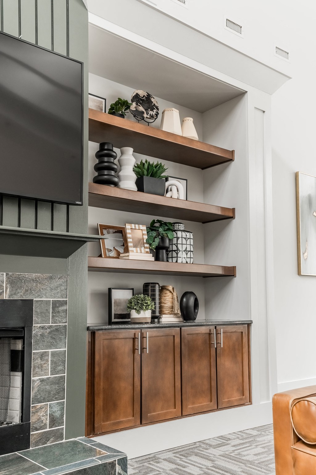 a living room with shelves and a fireplace and a tv