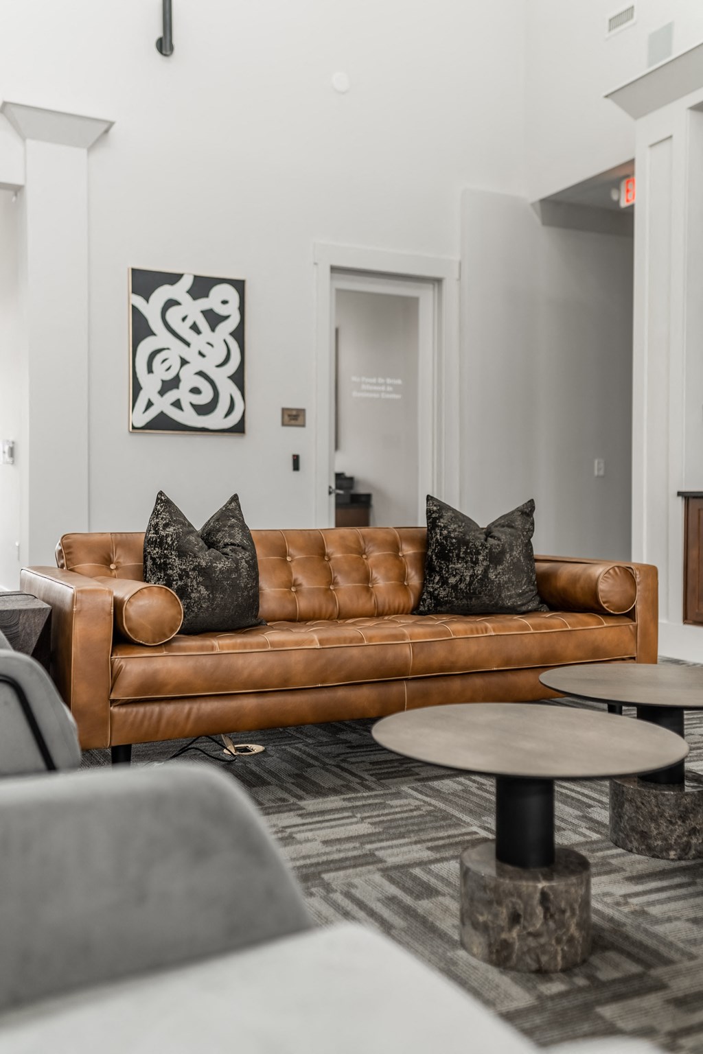 a living room with a brown couch and tables