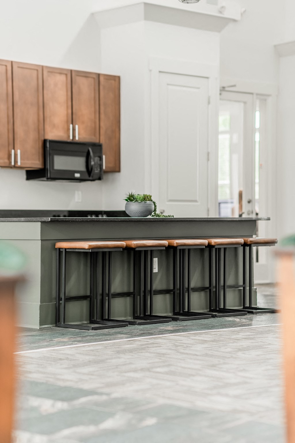 a kitchen island with a black counter top and a microwave
