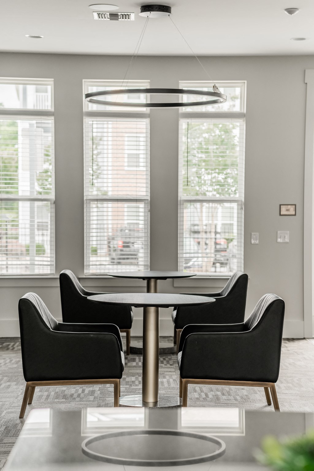 a dining room with chairs and a table and large windows