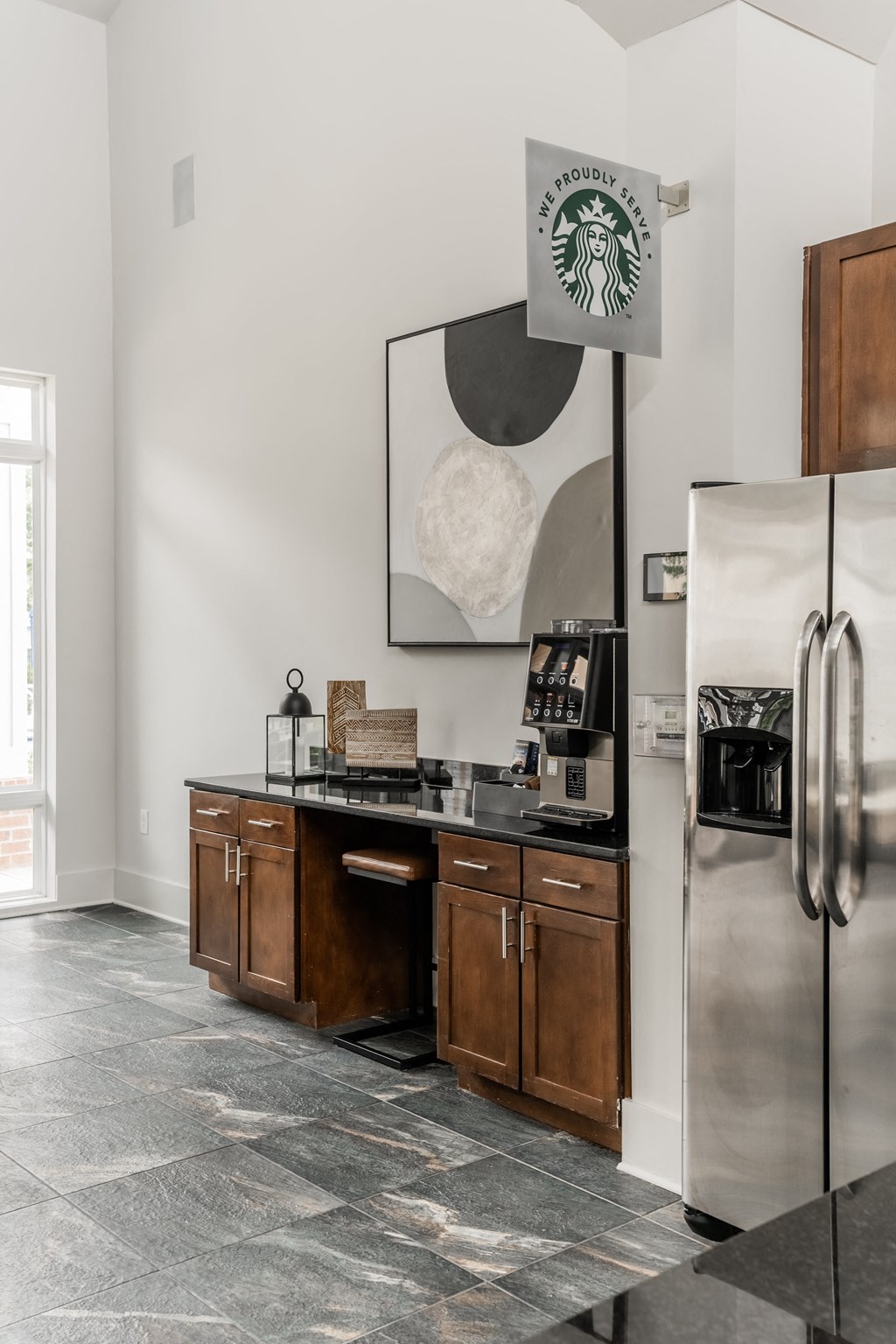 a kitchen with a stainless steel refrigerator and a counter with wooden cabinets