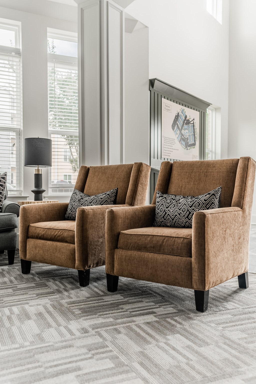 a living room with two brown chairs and a rug
