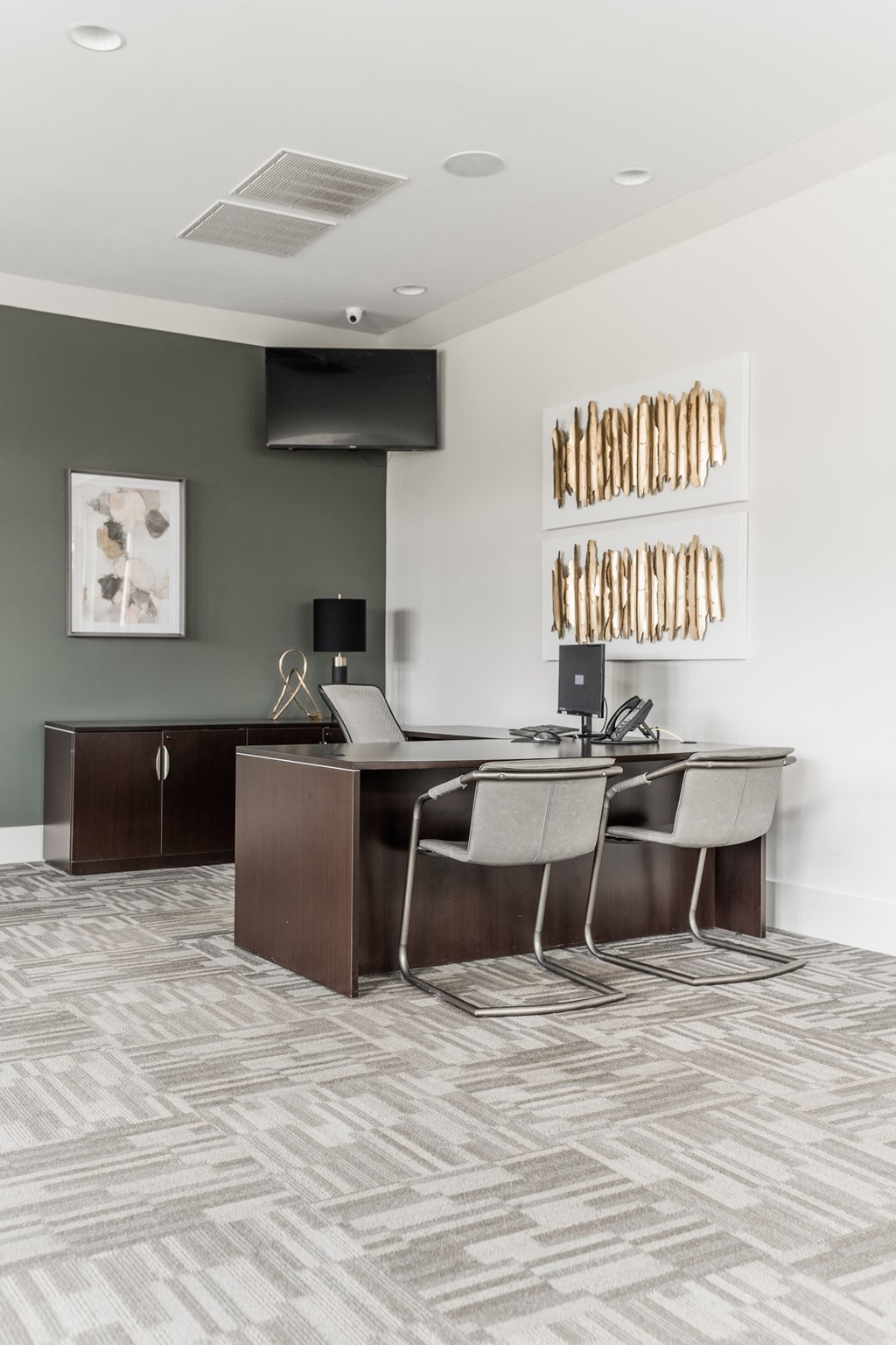 a conference room with a desk and chairs and a television