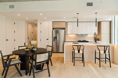A modern kitchen with a dining table set for four.