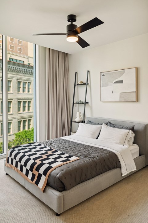 A bedroom with a large bed and a ceiling fan.