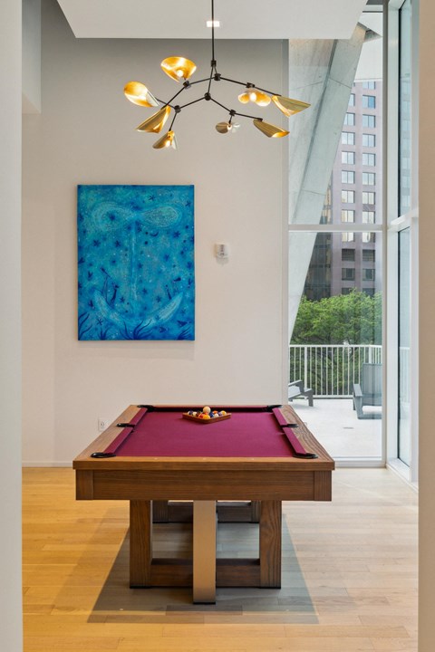 A pool table with a red cloth and a pool cue on it.