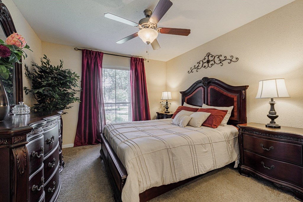 a bedroom with a large bed and a ceiling fan