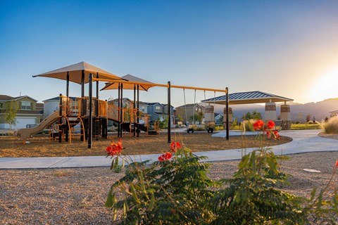 A playground with a slide and a canopy structure is surrounded by houses.