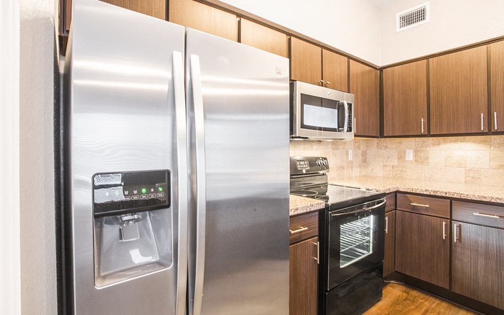 a kitchen with stainless steel appliances and wooden cabinets