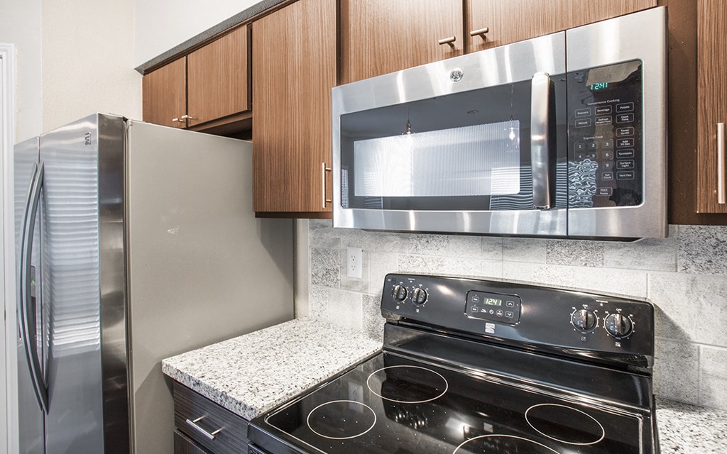 a kitchen with a stainless steel microwave and a stove