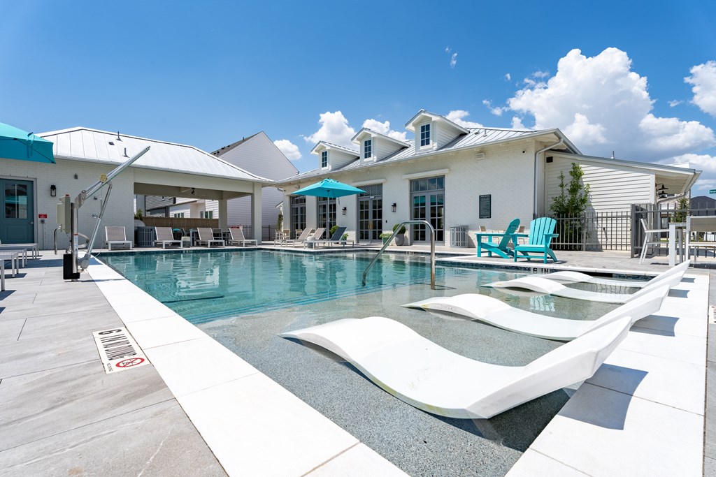 A pool with a slide and a house in the background.