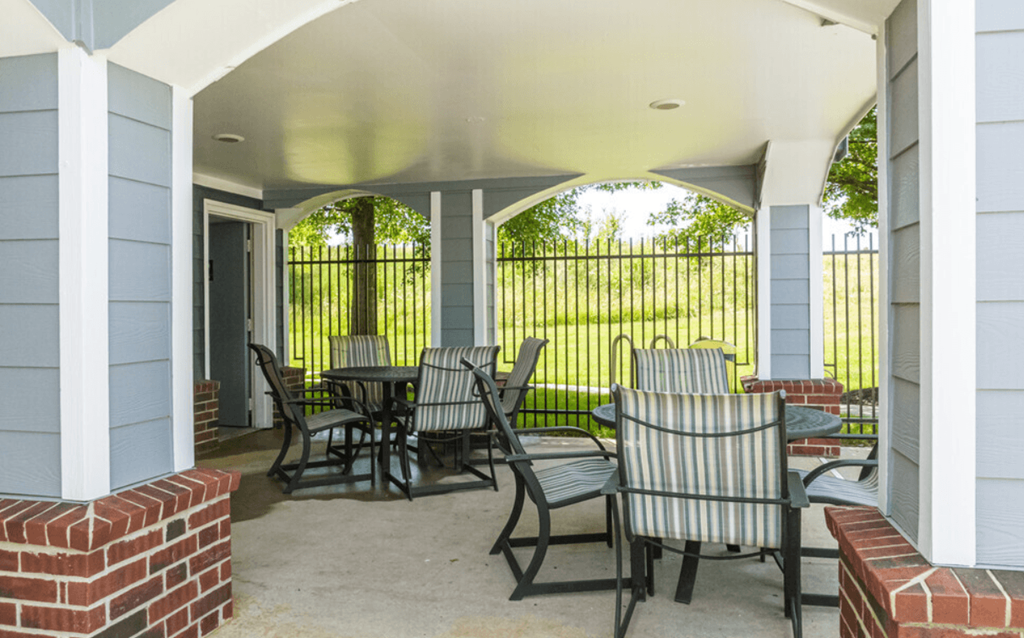 a covered patio with tables and chairs on a house