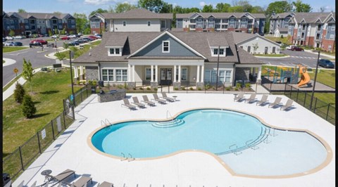 an aerial view of a swimming pool with chairs in front of a house
