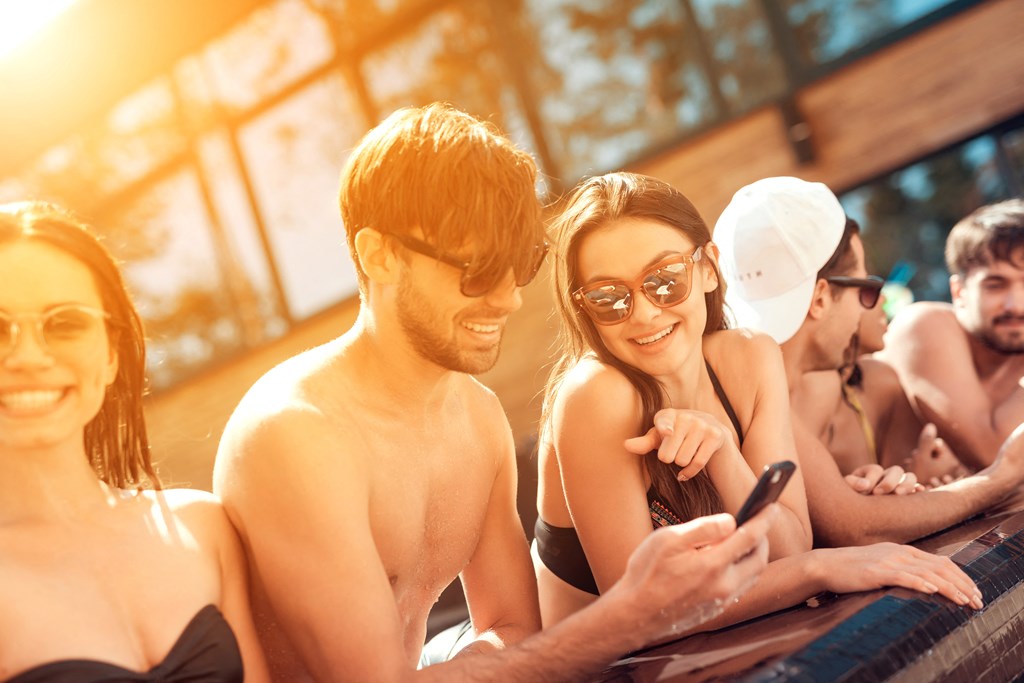 a group of people in a pool looking at their phone
