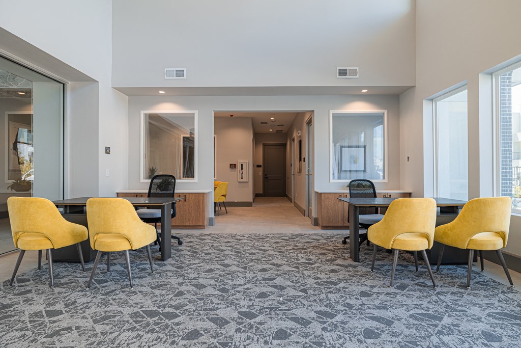 a seating area with yellow chairs and a gray carpet