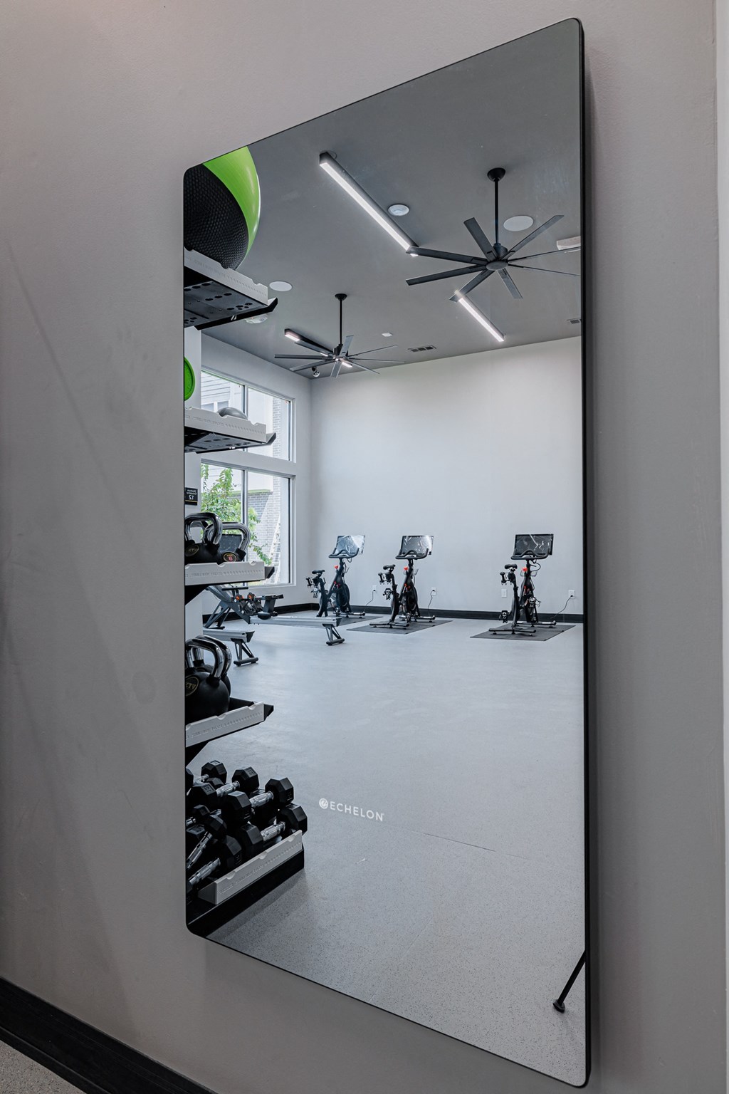 a large mirror hanging on a wall in a gym