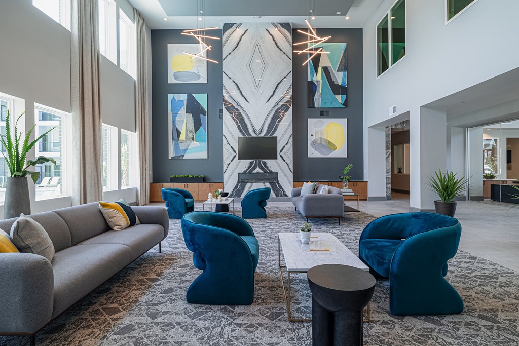 a large living room with blue chairs and couches