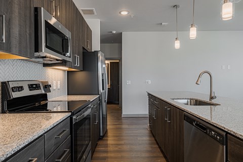 an updated kitchen with granite counter tops and black appliances