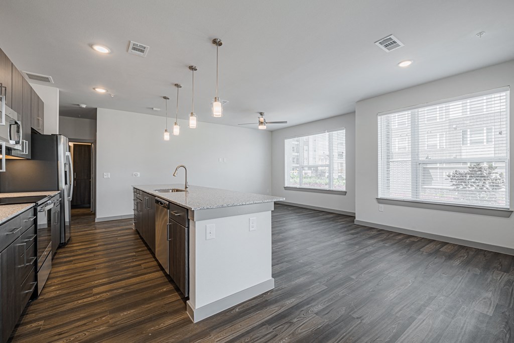 a kitchen and living room with hardwood floors and white walls