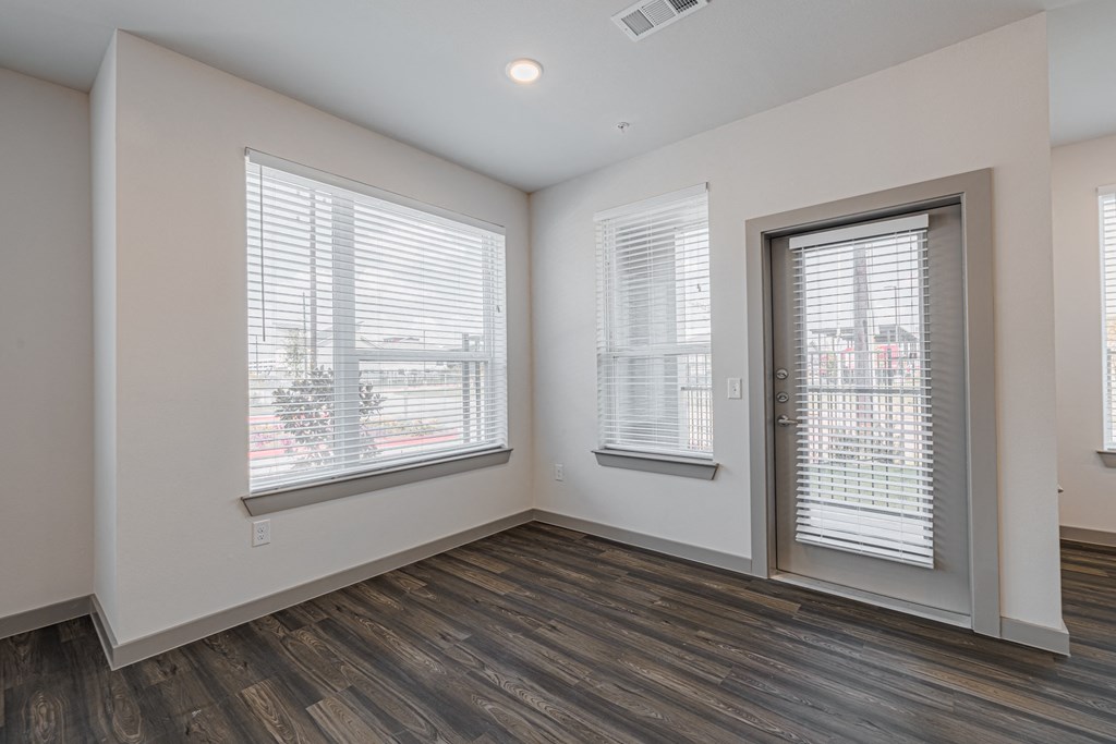 a bedroom with hardwood floors and white walls