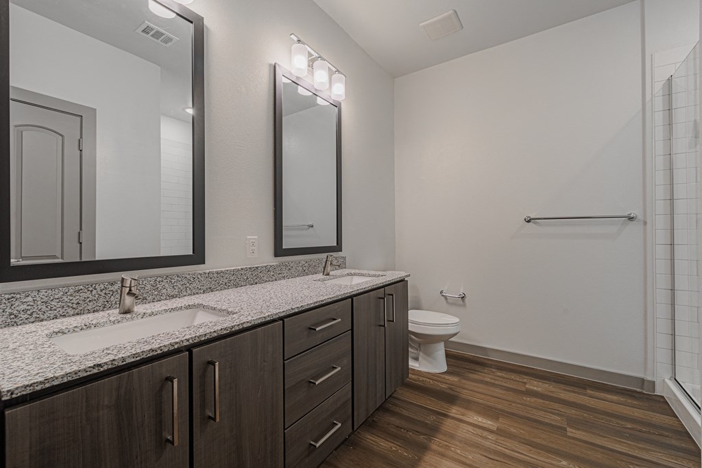 a bathroom with two sinks and a toilet