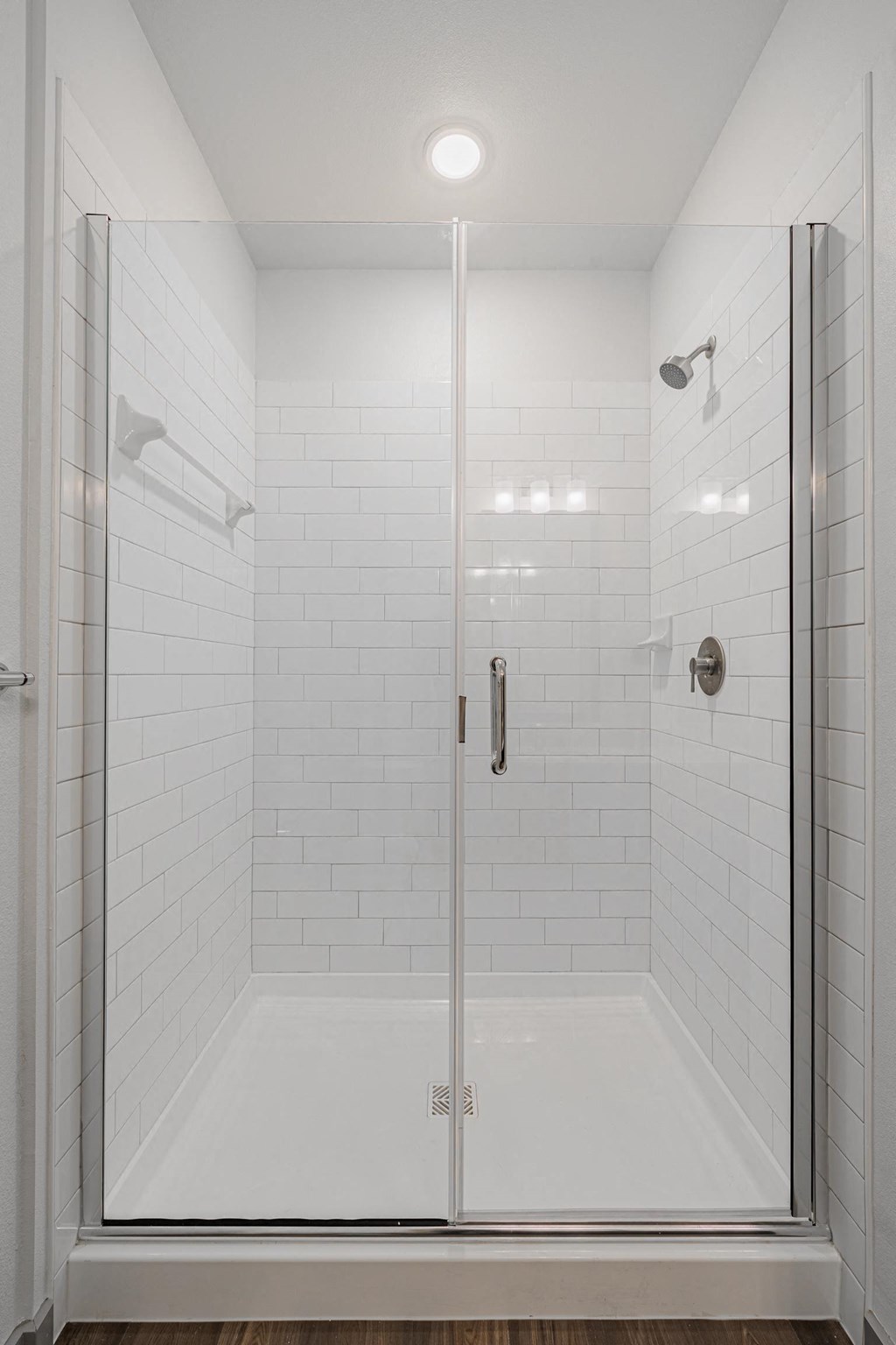 a white tiled shower in a 555 waverly unit