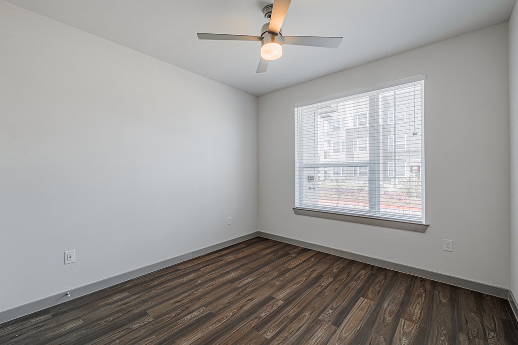a bedroom with hardwood floors and a ceiling fan