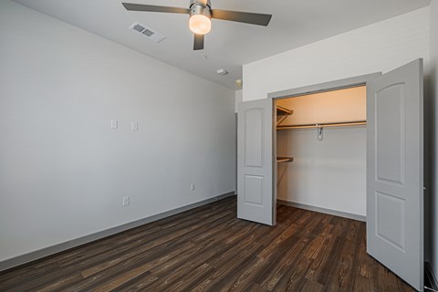 a bedroom with hardwood floors and a ceiling fan