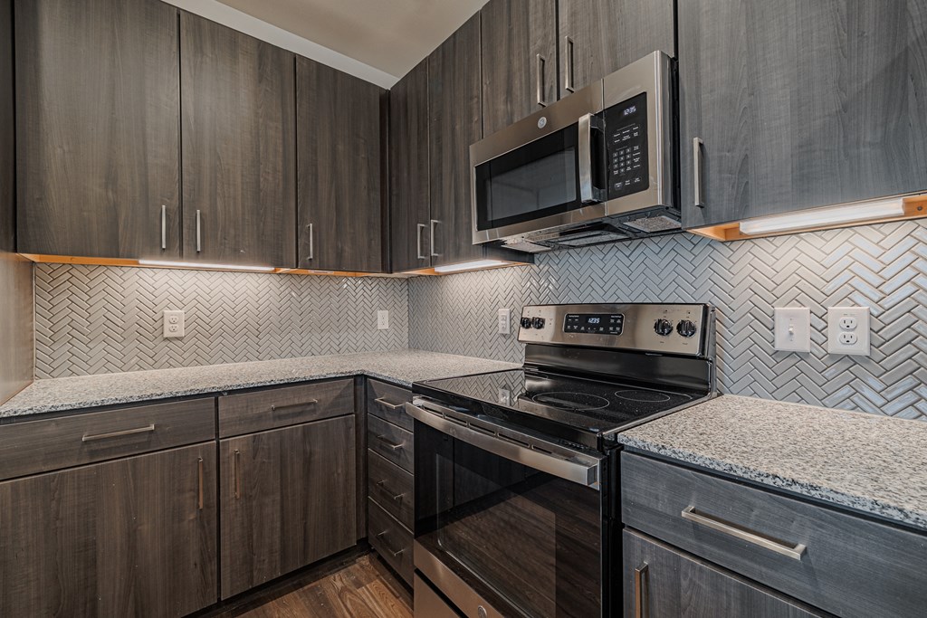 a kitchen with dark wood cabinets and white countertops
