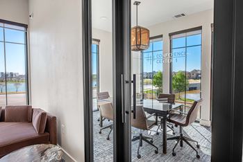 a dining room with a table and chairs next to a window