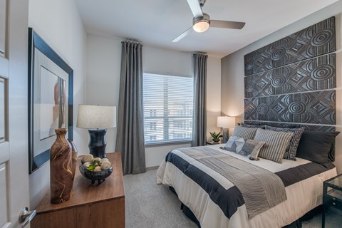 A bedroom with a large bed and a ceiling fan.