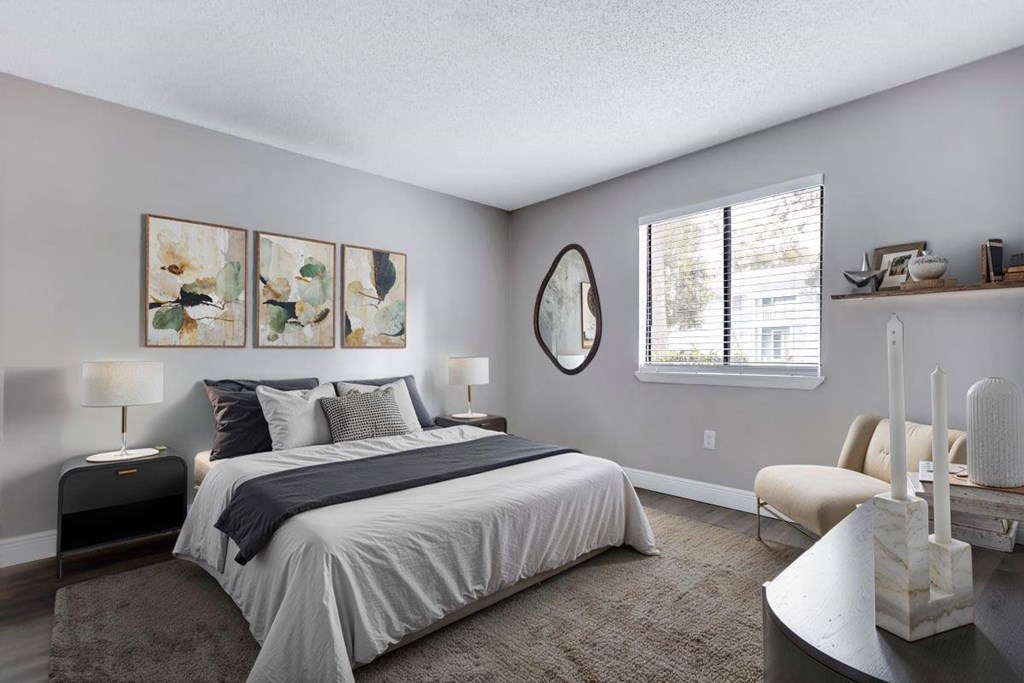 A bedroom with a large bed and a chair.