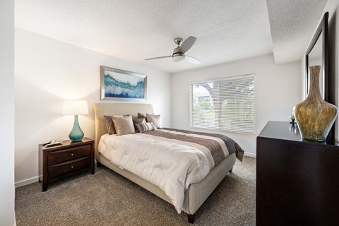 a bedroom with a bed and a ceiling fan