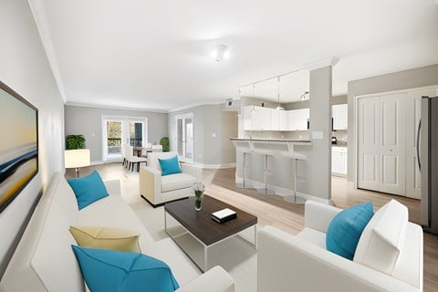 a living room and kitchen with white furniture and blue pillows