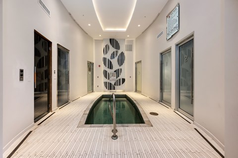a swimming pool in the middle of a room with glass doors