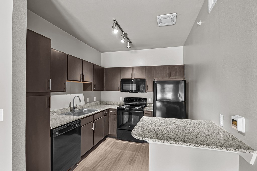 a kitchen with granite counter tops and black appliances