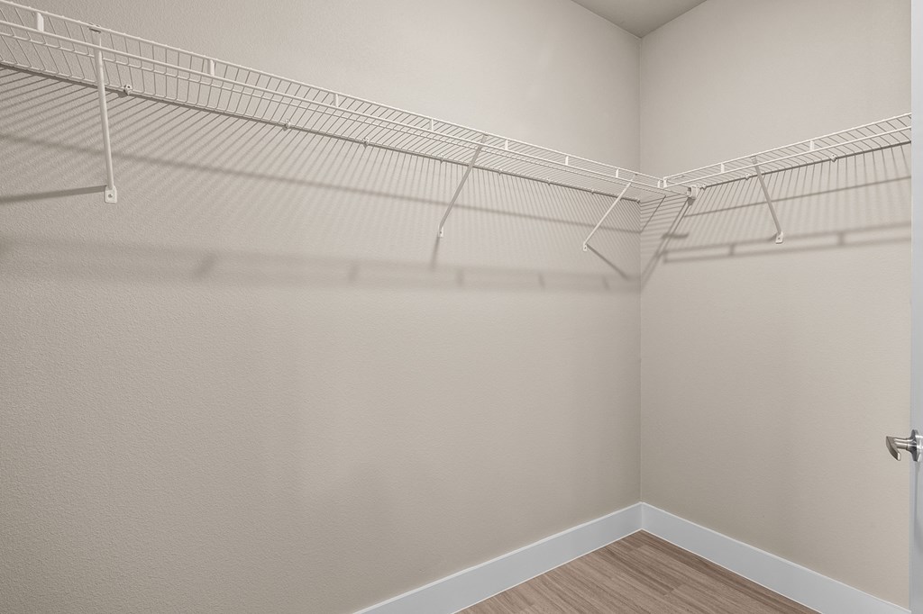 our spacious closets in the living room of a home with white walls and shelves