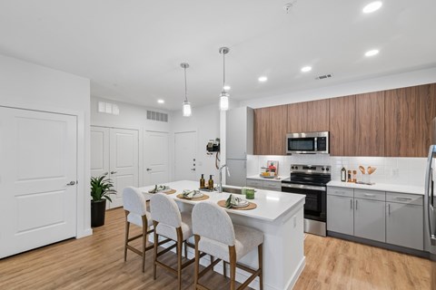A modern kitchen with a dining table set for four.