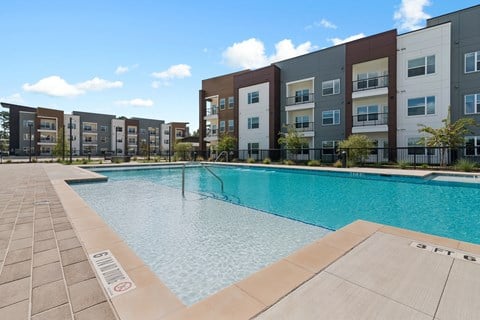 A swimming pool in front of apartment buildings.