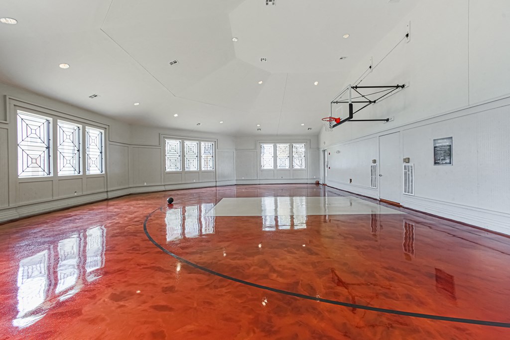 a large room with a basketball hoop and windows
