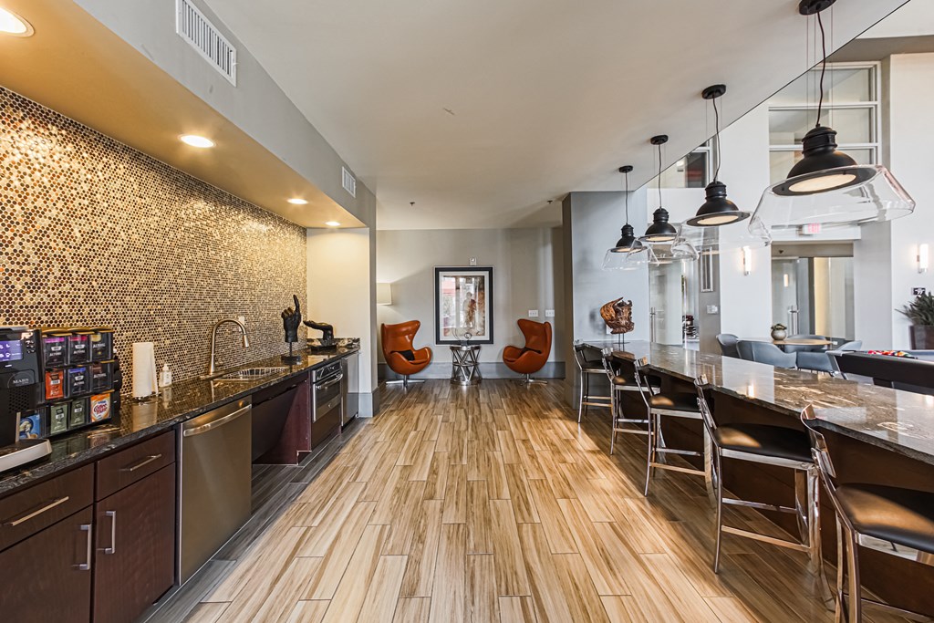 a kitchen with a long counter and chairs