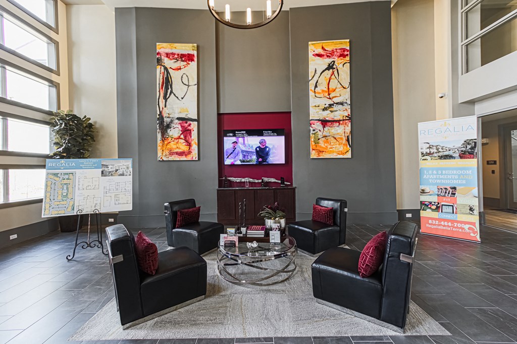 a lounge area with black leather chairs and a glass coffee table