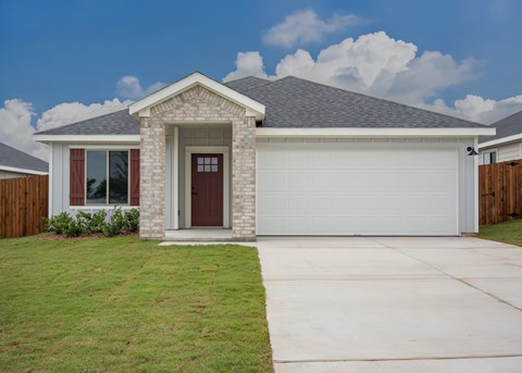 A house with a brown door and a grey roof.
