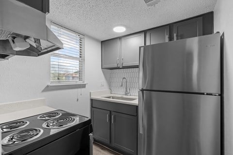 the kitchen of our studio apartment atrium with stainless steel appliances and black cabinets