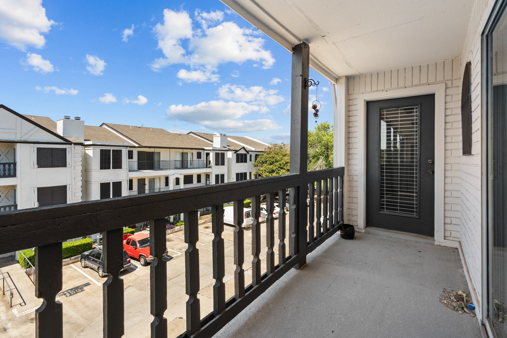 the view from the balcony of a home with a black railing and a door