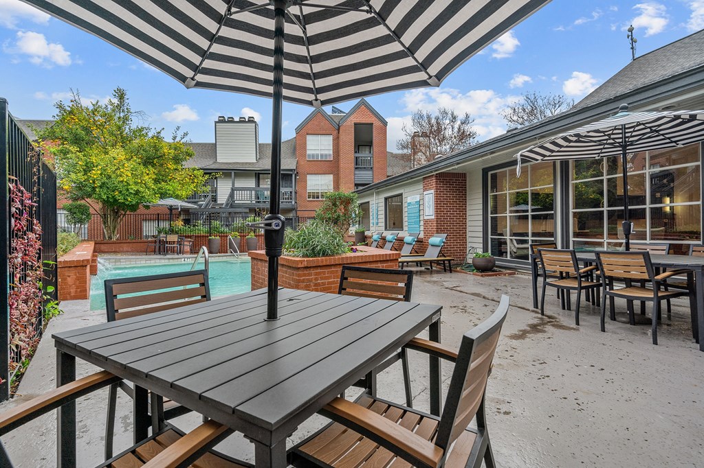 an outdoor patio with tables and chairs and a pool